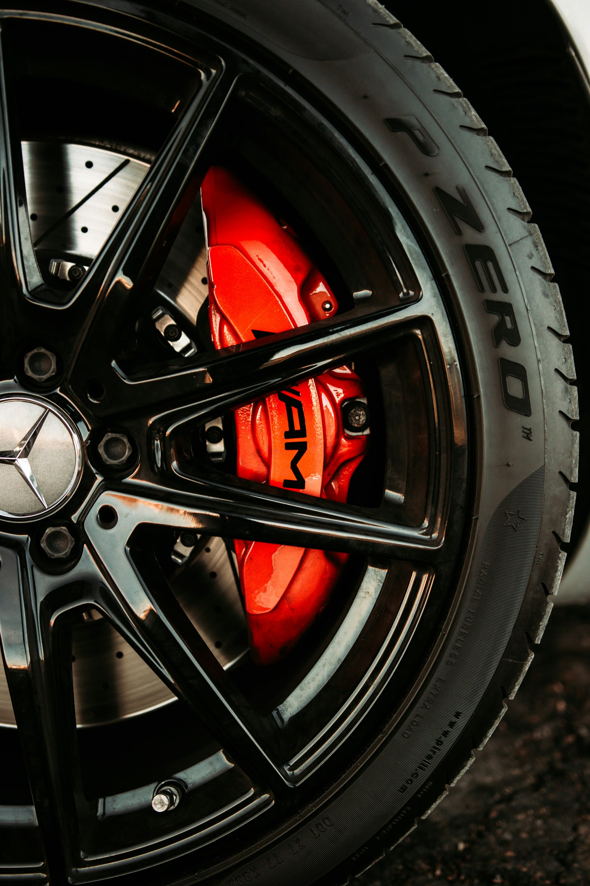 Red performance brake caliper behind a forged alloy wheel
