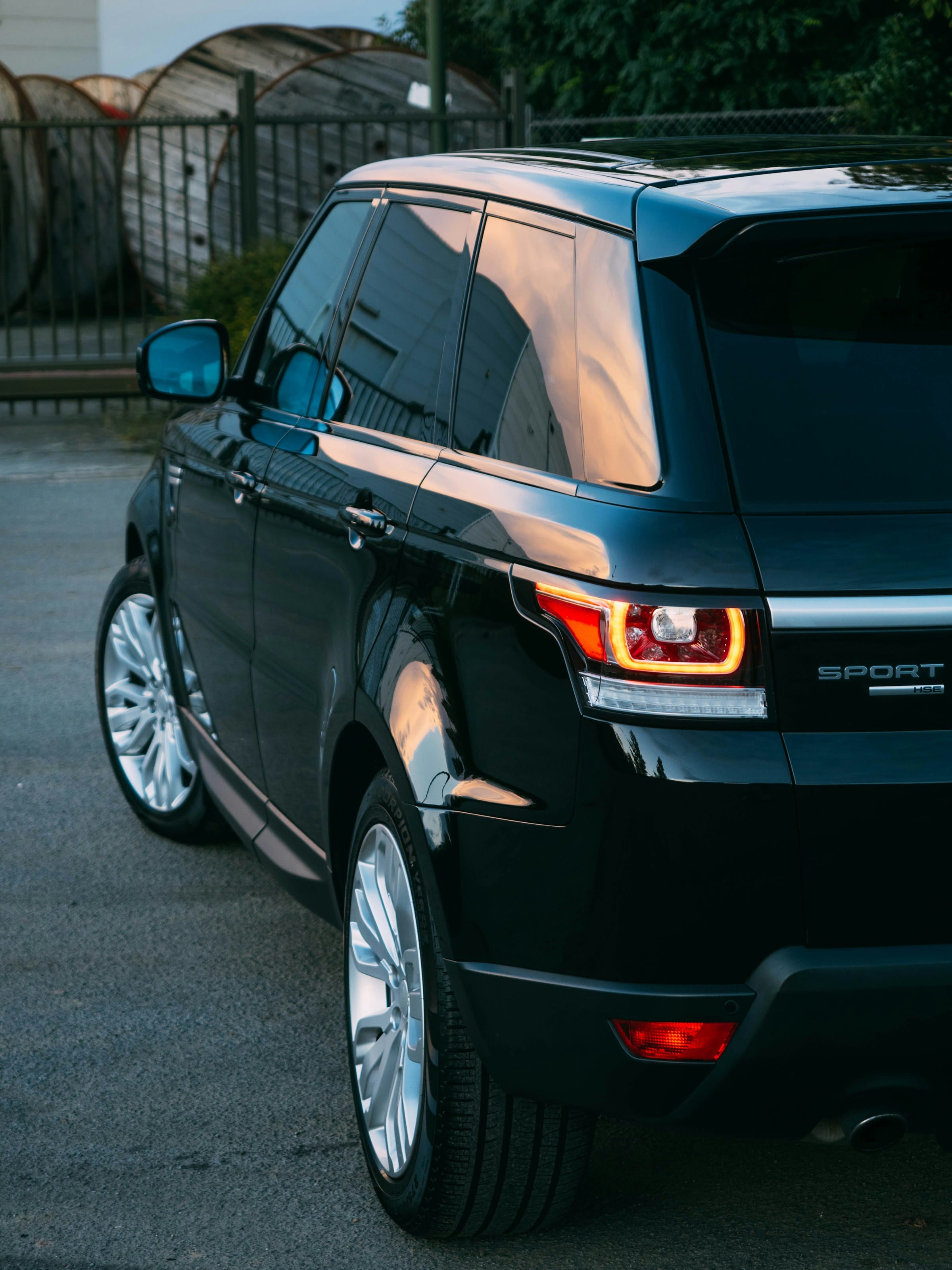 Rear quarter of a black Range Rover Sport at dusk